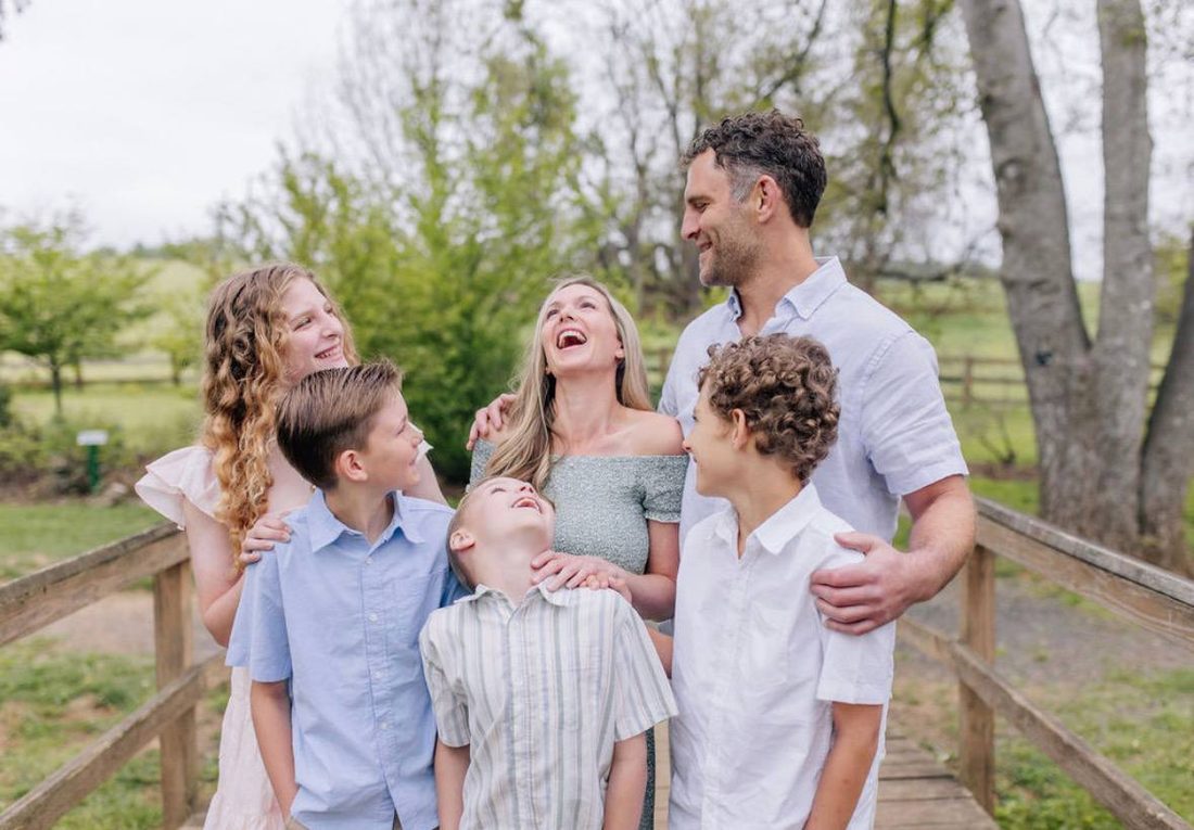 Tyler and his family enjoying a walk together on a wooden bridge in a green park near Warrenton, Virginia