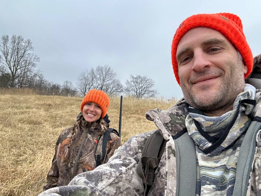Tyler in camouflage and an orange beanie out on a hunt in the Virginia countryside